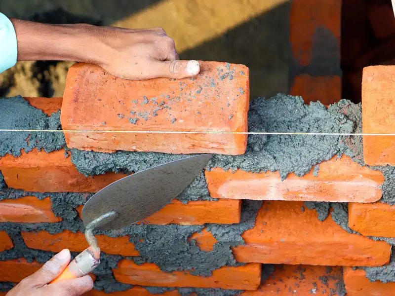Montage d’un mur en briques au mortier, au cordeau